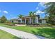 Beautiful home exterior featuring manicured landscaping, palm trees, and elegant architectural details under a bright blue sky at 11807 Rive Isle Run, Parrish, FL 34219