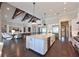 Open-concept kitchen with a large island flowing into the living area with wood beam details at 11807 Rive Isle Run, Parrish, FL 34219