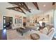 Open-concept living room with wooden beams, comfortable seating, and views of the kitchen at 11807 Rive Isle Run, Parrish, FL 34219