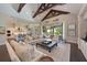 Open-concept living room with high ceilings, wood beams, and seamless flow to the kitchen and outdoor spaces at 11807 Rive Isle Run, Parrish, FL 34219