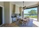 Outdoor kitchen with a built-in grill, refrigerator, dining table, and beautiful lake views at 11807 Rive Isle Run, Parrish, FL 34219