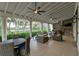 Expansive covered outdoor living area featuring comfortable seating, an outdoor kitchen and scenic backyard views at 11807 Rive Isle Run, Parrish, FL 34219