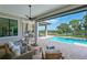 Covered patio with an outdoor kitchen, ceiling fans, and comfortable seating overlooking the pool and water at 11807 Rive Isle Run, Parrish, FL 34219