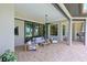 Spacious covered patio with modern seating, a ceiling fan, and access to an outdoor kitchen area at 11807 Rive Isle Run, Parrish, FL 34219