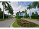 Picturesque street view lined with palm trees and colorful flowerbeds, leading to a beautiful home in The Islands at 11807 Rive Isle Run, Parrish, FL 34219