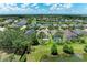 Aerial view of home showcasing landscaping, screened pool, and surrounding neighborhood with pond views at 11811 Fennemore Way, Parrish, FL 34219