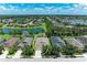 Aerial view of a residential home in a lakeside community with lush greenery and neighboring houses at 11811 Fennemore Way, Parrish, FL 34219