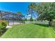 Manicured backyard with lush lawn and view of the screened patio at 11811 Fennemore Way, Parrish, FL 34219
