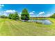 Scenic backyard view of a tranquil pond surrounded by lush greenery and trees at 11811 Fennemore Way, Parrish, FL 34219
