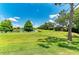 Lush backyard with a tranquil pond view, enhanced by mature trees and landscaping at 11811 Fennemore Way, Parrish, FL 34219