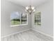 The dining room features a modern chandelier and large windows with picturesque backyard views at 11811 Fennemore Way, Parrish, FL 34219