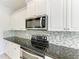Updated kitchen with white cabinets, stainless steel microwave and oven, and tiled backsplash at 11811 Fennemore Way, Parrish, FL 34219