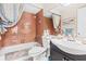 Bathroom featuring a shower-tub combo with neutral tile and a black vanity, providing a clean and functional space at 1355 Rock Dove Ct # 1-2, Punta Gorda, FL 33950