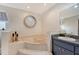 Cozy bathroom featuring a soaking tub with tile surround, vanity with granite countertop and modern fixtures at 1626 Ridgewood Ln, Sarasota, FL 34231