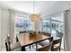 Dining room with a view of the pool, modern light fixture, and sliding glass doors to the lanai at 1626 Ridgewood Ln, Sarasota, FL 34231