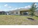 Large backyard featuring green grass, the back of the home, and a covered patio at 17536 Cantarina Cv, Bradenton, FL 34211