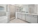 Beautiful bathroom featuring a glass enclosed shower, double vanity with marble counter tops, and tile flooring at 17536 Cantarina Cv, Bradenton, FL 34211