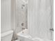 Neutral bathroom with a shower featuring gray tile and a shower curtain at 17536 Cantarina Cv, Bradenton, FL 34211