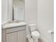 Clean powder room with a white vanity, granite counters, and a modern toilet at 17536 Cantarina Cv, Bradenton, FL 34211