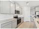 Well-lit kitchen featuring stainless steel appliances, light grey cabinetry, and stylish tile flooring at 17536 Cantarina Cv, Bradenton, FL 34211