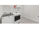 Well-lit laundry room featuring a modern washer, dryer, and shelving for storage at 17536 Cantarina Cv, Bradenton, FL 34211