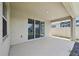 Covered outdoor patio with a glimpse of the pond and neighboring fence at 17536 Cantarina Cv, Bradenton, FL 34211
