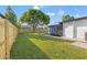 Spacious backyard featuring a lush lawn, privacy fence and an inviting screened-in porch at 1801 W Saint Isabel St, Tampa, FL 33607