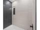 Modern bathroom with light and dark gray tiling, contrasting beautifully against the white tub at 1801 W Saint Isabel St, Tampa, FL 33607