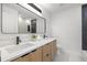 Modern bathroom featuring a double vanity, a large mirror, and a shower with black tile accents at 1801 W Saint Isabel St, Tampa, FL 33607