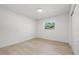 Bedroom featuring light wood floors, white walls, and natural light from the large window at 1801 W Saint Isabel St, Tampa, FL 33607