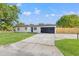 Charming single-story home featuring a black garage door and a well-manicured lawn at 1801 W Saint Isabel St, Tampa, FL 33607