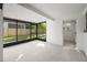 Light-filled sun room with screened windows overlooking a fenced backyard and tiled floors at 1801 W Saint Isabel St, Tampa, FL 33607