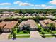 Beautiful aerial view of the property featuring a tile roof, paver driveway, and mature trees at 2152 Majestic Oaks Blvd, Clearwater, FL 33759
