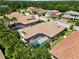 Aerial view of home featuring a screened-in pool area surrounded by beautiful tropical foliage at 2152 Majestic Oaks Blvd, Clearwater, FL 33759