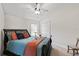 This bedroom features neutral walls, carpet, a ceiling fan, and a black bed with blue/orange accents at 2152 Majestic Oaks Blvd, Clearwater, FL 33759