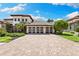 Stunning two-story home showcasing a paver driveway and a spacious three-car garage at 2152 Majestic Oaks Blvd, Clearwater, FL 33759