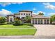 Beautifully landscaped front yard of a luxury home, showcasing a manicured lawn and a three-car garage at 2152 Majestic Oaks Blvd, Clearwater, FL 33759
