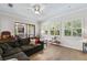 Bright living room with wood floors, neutral walls, large windows with shutters, and a comfy grey sectional at 2152 Majestic Oaks Blvd, Clearwater, FL 33759