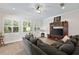 Cozy living room with a plush grey sectional couch, wood floors, and bright windows with plantation shutters at 2152 Majestic Oaks Blvd, Clearwater, FL 33759