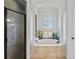 This primary bathroom features a tiled, columned tub, tile flooring, and an glass enclosed shower at 2152 Majestic Oaks Blvd, Clearwater, FL 33759