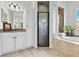 This primary bathroom features a tiled, columned tub, tile flooring, vanity, and glass enclosed shower at 2152 Majestic Oaks Blvd, Clearwater, FL 33759