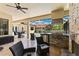 Outdoor living area with a built-in grill, fireplace, seating, and a screened-in pool in the background at 2152 Majestic Oaks Blvd, Clearwater, FL 33759