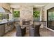 Outdoor kitchen and fireplace area with a stone facade, built-in grill, and comfortable seating at 2152 Majestic Oaks Blvd, Clearwater, FL 33759