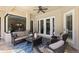 Covered outdoor patio area with comfortable seating, a coffee table, and access to the interior of the home at 2152 Majestic Oaks Blvd, Clearwater, FL 33759