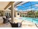 Private backyard oasis with a screened-in pool, comfortable seating, and well-maintained landscaping at 2152 Majestic Oaks Blvd, Clearwater, FL 33759
