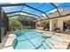 Inviting screened-in pool with sun shelf, spa, and outdoor kitchen providing endless summer fun at 2152 Majestic Oaks Blvd, Clearwater, FL 33759