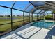 A screened-in pool area features cool decking and a view of the adjacent lake at 2178 Calcutta Rd, Punta Gorda, FL 33983