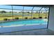 Sparkling in-ground swimming pool with a screened enclosure and a serene lake view beyond at 2178 Calcutta Rd, Punta Gorda, FL 33983