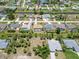 Real estate aerial view of canal-front single-Gathering homes, palm trees, green lawns, and peaceful community at 251 Broadmoor Ln, Rotonda West, FL 33947