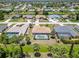 Real estate aerial view features neighborhood homes with screened pools and lake views with palm trees at 251 Broadmoor Ln, Rotonda West, FL 33947